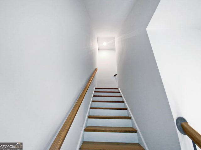 stairway featuring wood finished floors and baseboards