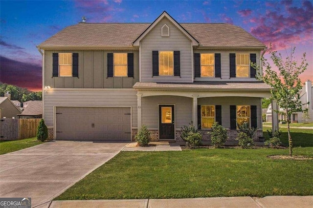 view of front facade featuring a lawn, a porch, and a garage