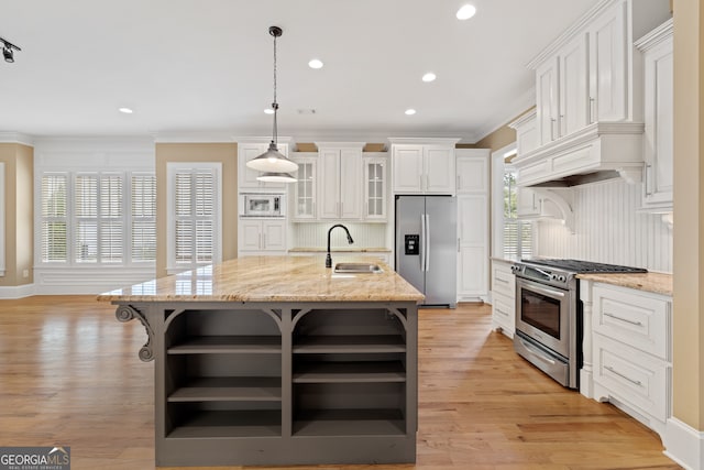 kitchen featuring a kitchen island with sink, appliances with stainless steel finishes, light hardwood / wood-style flooring, and white cabinets