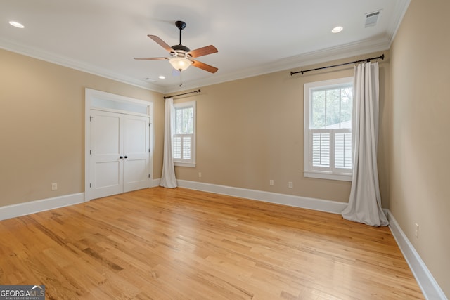 unfurnished bedroom featuring crown molding, light wood-type flooring, multiple windows, and ceiling fan