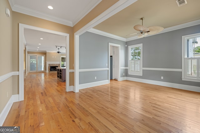 unfurnished room with light wood-type flooring, ceiling fan, and crown molding