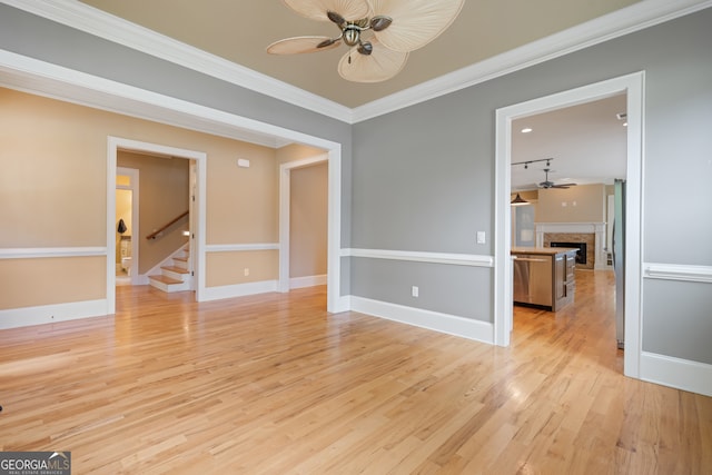 interior space with crown molding, ceiling fan, stainless steel refrigerator, and light wood-type flooring