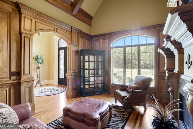 interior space featuring light wood-type flooring, high vaulted ceiling, and beam ceiling