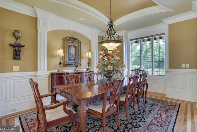 dining room featuring ornamental molding, hardwood / wood-style flooring, and decorative columns