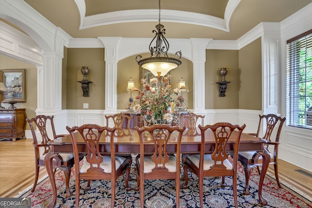 dining area featuring crown molding, plenty of natural light, light hardwood / wood-style flooring, and decorative columns