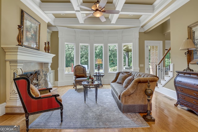 living room featuring ceiling fan, coffered ceiling, beamed ceiling, and light wood-type flooring