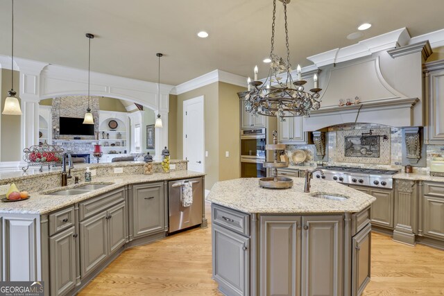 kitchen featuring light wood-type flooring, a center island with sink, and sink