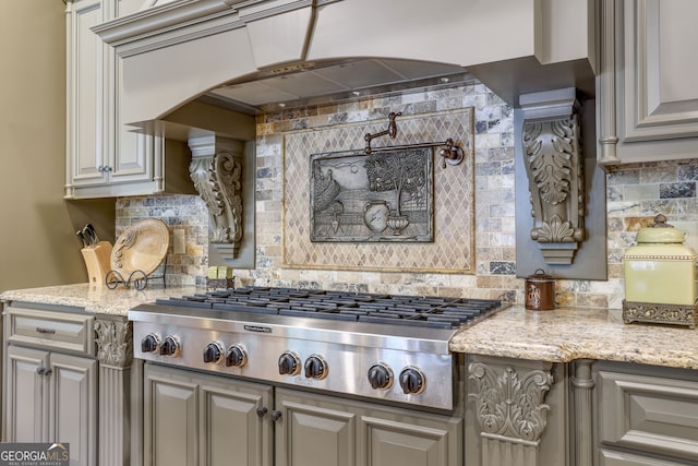 kitchen with stainless steel gas stovetop and light stone countertops