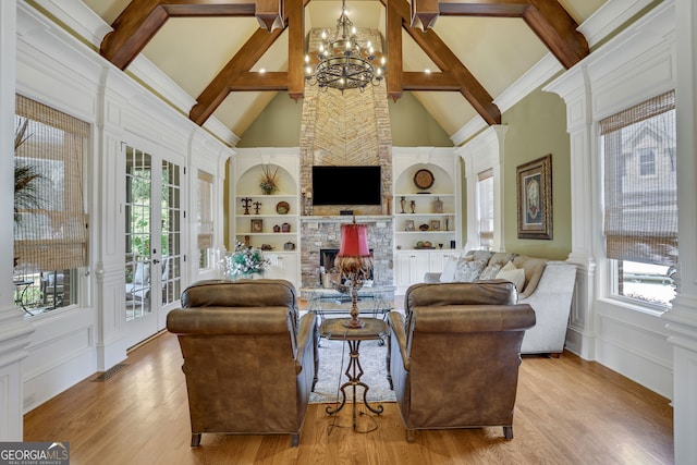 living room with an inviting chandelier, light hardwood / wood-style flooring, beam ceiling, built in features, and high vaulted ceiling