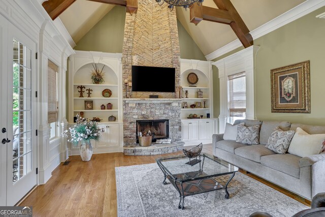 living room featuring a fireplace, light hardwood / wood-style flooring, built in features, high vaulted ceiling, and beam ceiling