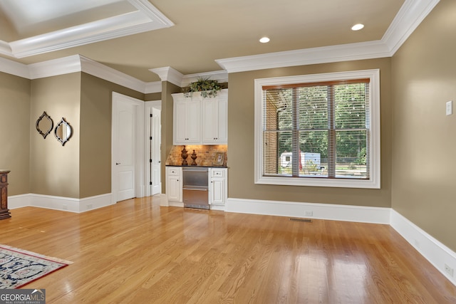 unfurnished living room featuring ornamental molding and light wood-type flooring