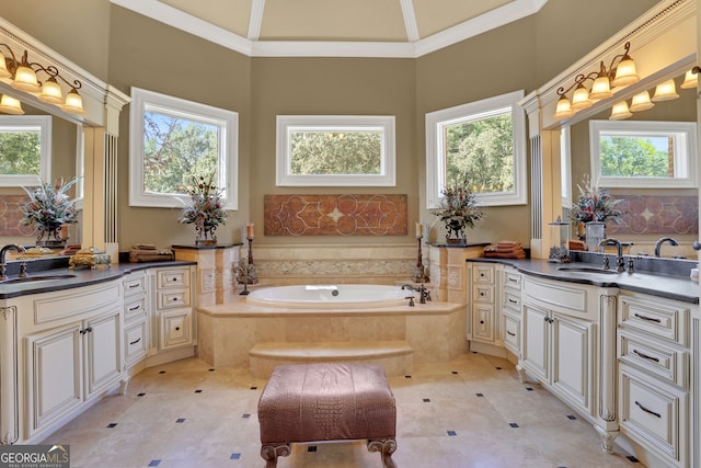 bathroom with crown molding, vanity, a relaxing tiled tub, and a wealth of natural light