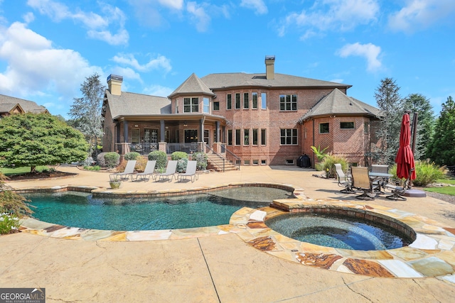 view of swimming pool featuring a patio and an in ground hot tub