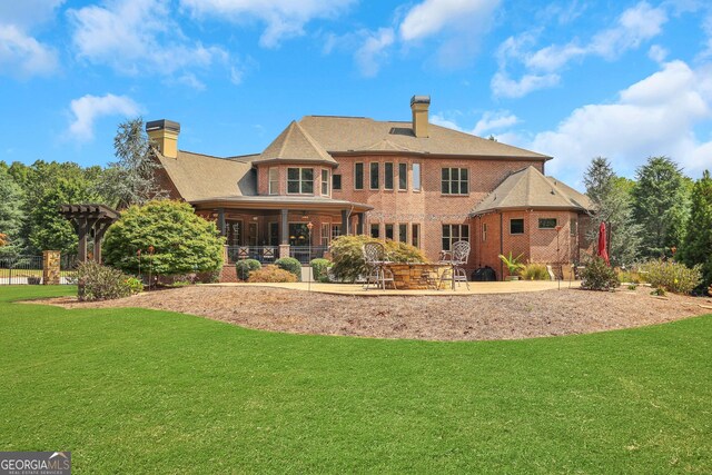 back of house featuring a lawn and a patio area