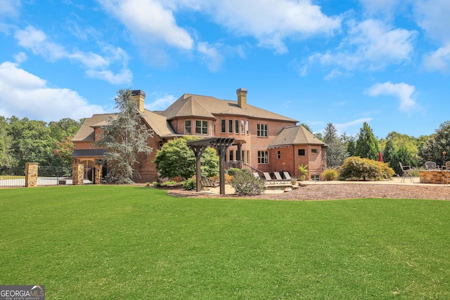 rear view of house featuring a pergola and a lawn