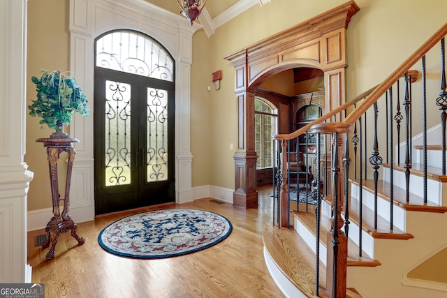 foyer with french doors, a wealth of natural light, and light hardwood / wood-style floors