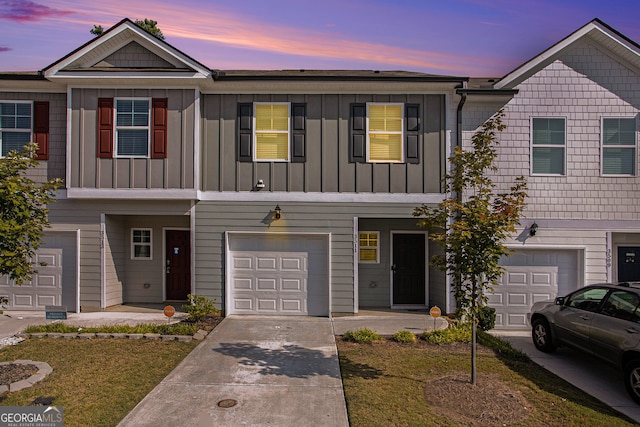 townhome / multi-family property featuring a yard and a garage