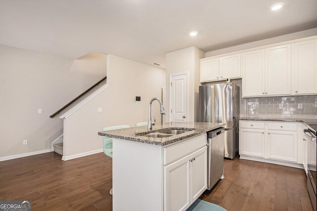 kitchen with dark hardwood / wood-style flooring, a center island with sink, stone countertops, sink, and white cabinets