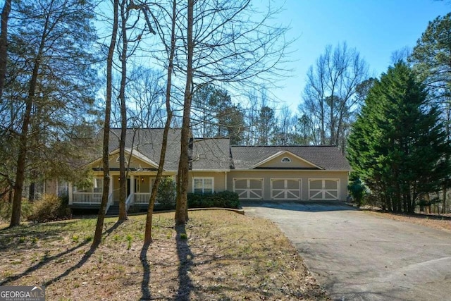 ranch-style house featuring a garage and covered porch