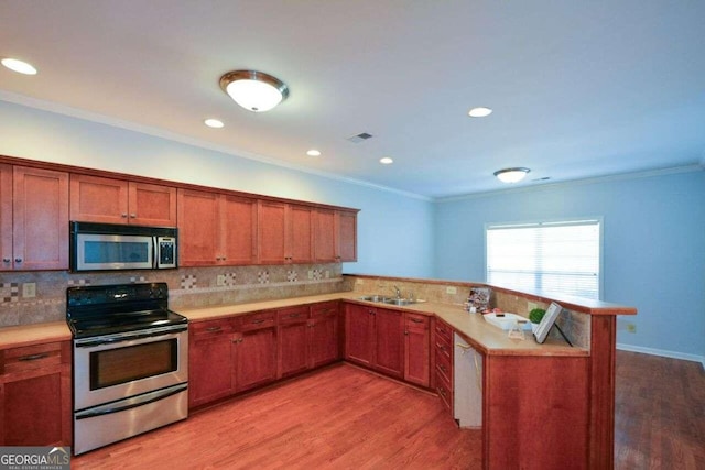 kitchen with light wood-type flooring, kitchen peninsula, stainless steel appliances, and backsplash