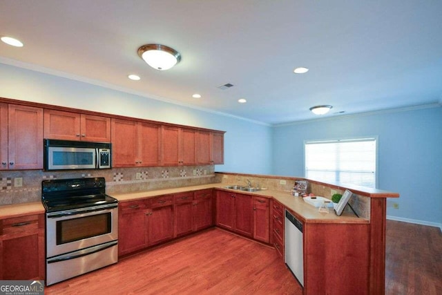 6865 Cowan Mill Rd, Winston, GA 30187 - kitchen featuring ornamental molding, light countertops, appliances with stainless steel finishes, and light wood-style floors