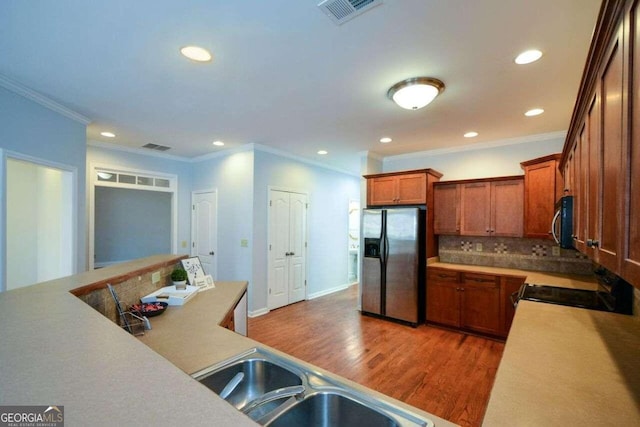 kitchen featuring dark hardwood / wood-style floors, tasteful backsplash, stainless steel appliances, ornamental molding, and sink