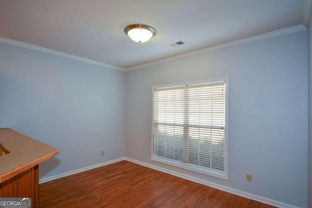 empty room with ornamental molding and wood-type flooring