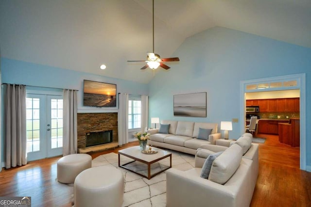 6865 Cowan Mill Rd, Winston, GA 30187 - living area featuring a fireplace, french doors, a ceiling fan, high vaulted ceiling, and light wood finished floors