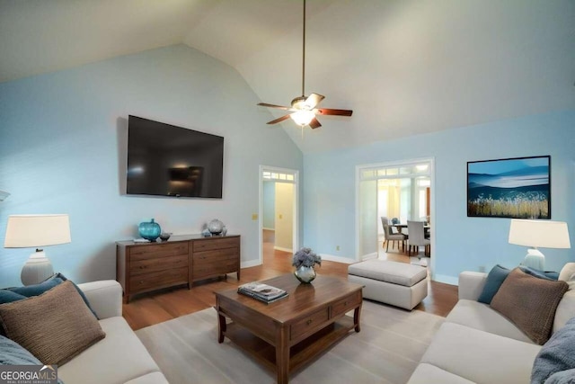 living room with ceiling fan, high vaulted ceiling, and light hardwood / wood-style floors