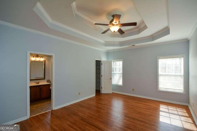 unfurnished bedroom with crown molding, hardwood / wood-style floors, ensuite bathroom, and multiple windows