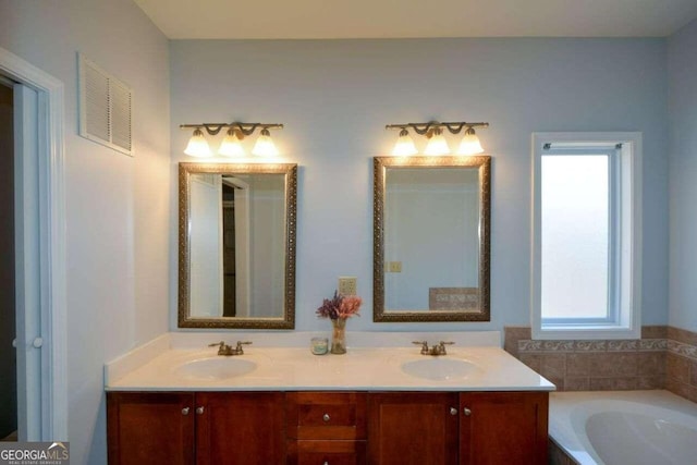 bathroom with vanity and a tub