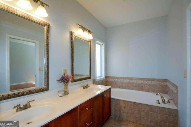 bathroom featuring tile patterned floors, tiled bath, and vanity