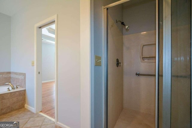 bathroom featuring plus walk in shower and tile patterned flooring