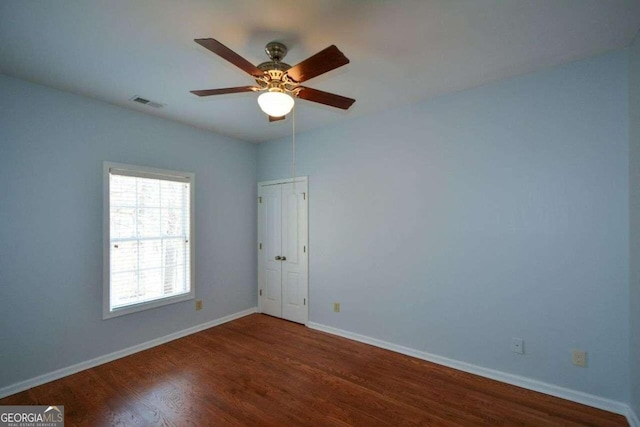 empty room featuring ceiling fan and dark hardwood / wood-style floors