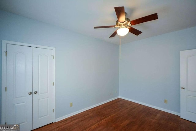 unfurnished bedroom featuring a closet, ceiling fan, and dark hardwood / wood-style flooring