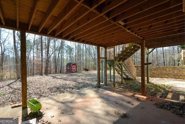 6865 Cowan Mill Rd, Winston, GA 30187 - view of patio featuring a storage shed, a forest view, an outdoor structure, and stairs
