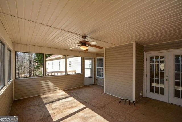 unfurnished sunroom with ceiling fan and french doors