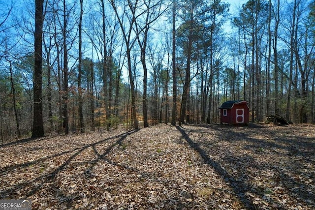 6865 Cowan Mill Rd, Winston, GA 30187 - view of yard with a storage shed, an outdoor structure, and a forest view