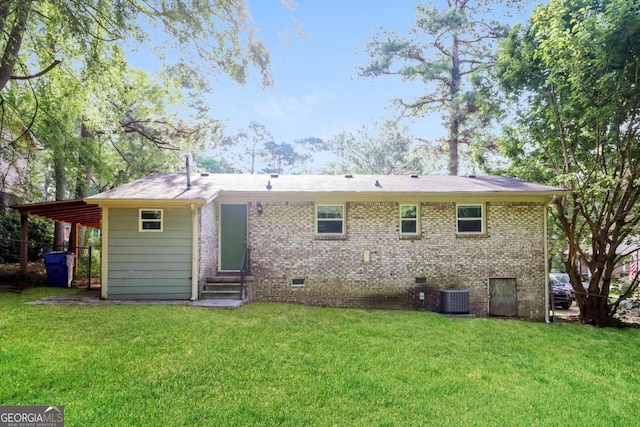 rear view of property featuring central AC, a yard, and a carport