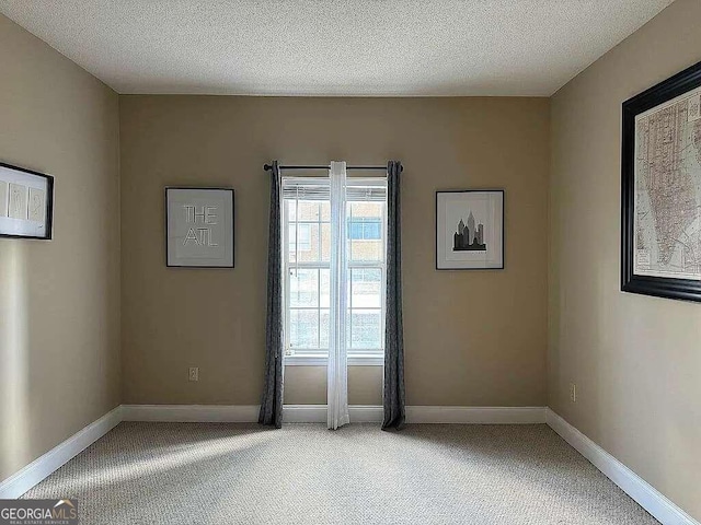 empty room featuring a textured ceiling and carpet floors