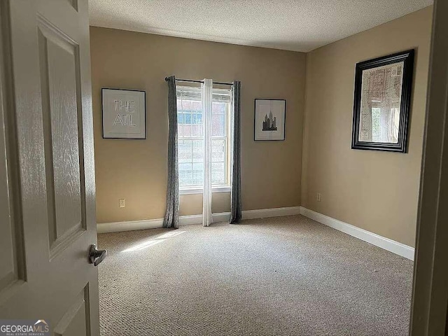 carpeted spare room featuring a textured ceiling