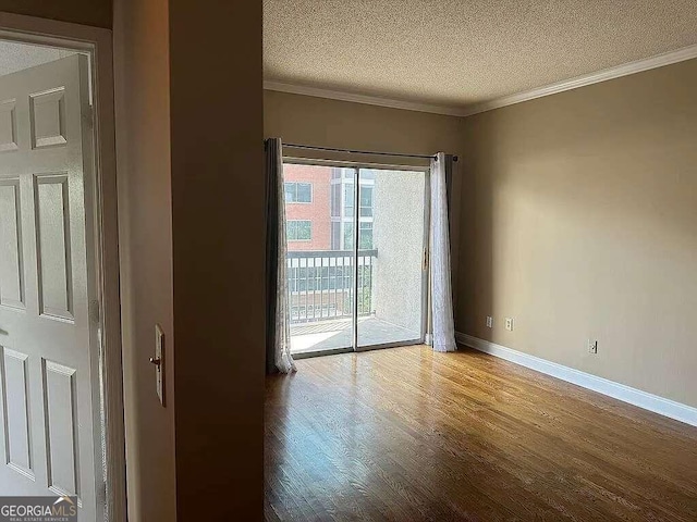 spare room featuring wood-type flooring, crown molding, and a textured ceiling