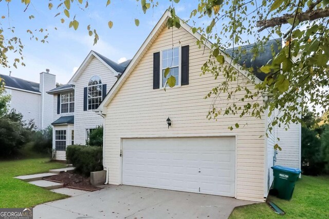 view of front of home with a garage and a front yard