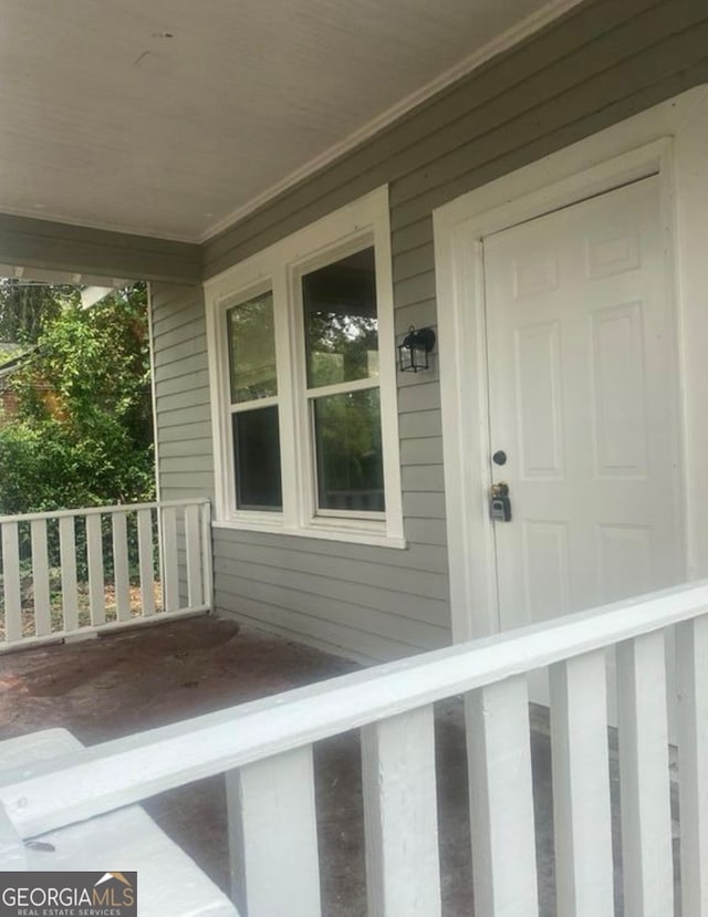 view of exterior entry featuring covered porch