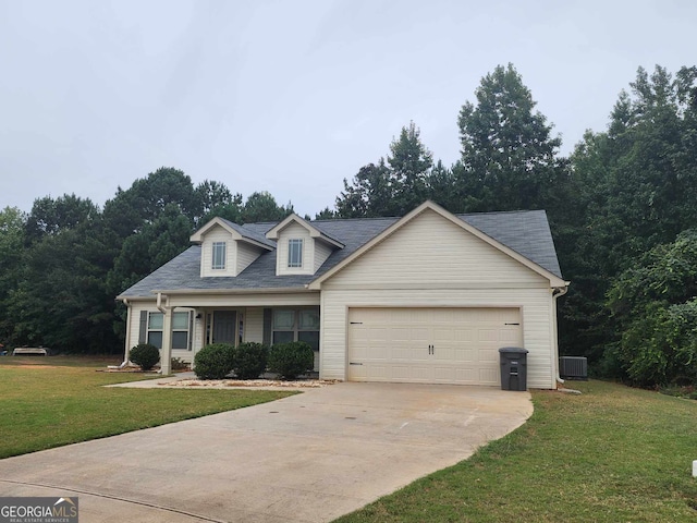 view of front of property with cooling unit, a garage, and a front yard