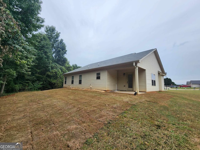 back of property featuring a yard