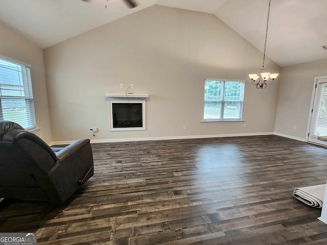 living room with high vaulted ceiling, ceiling fan with notable chandelier, and dark hardwood / wood-style flooring