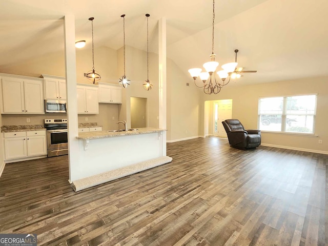 kitchen with hanging light fixtures, appliances with stainless steel finishes, white cabinetry, dark hardwood / wood-style floors, and high vaulted ceiling