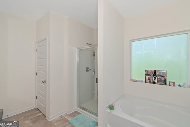 bathroom featuring separate shower and tub and hardwood / wood-style floors