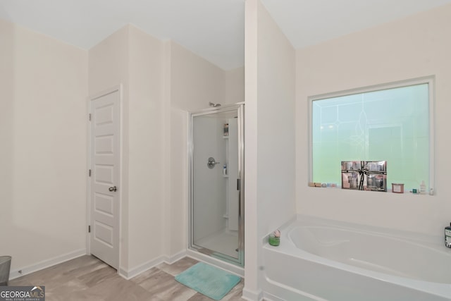 bathroom featuring separate shower and tub